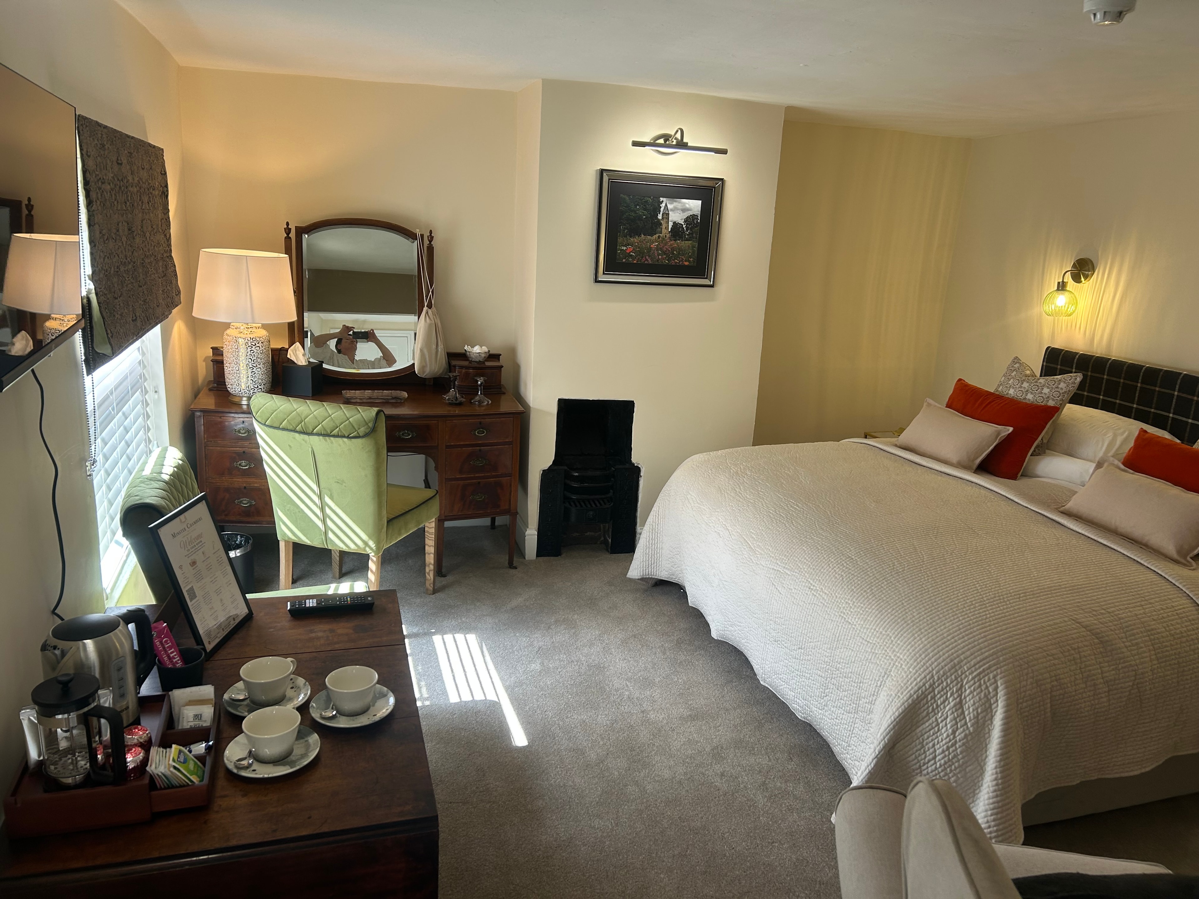 Chapel Suite — bedroom with tartan headboard, red cushions and en-suite beyond
