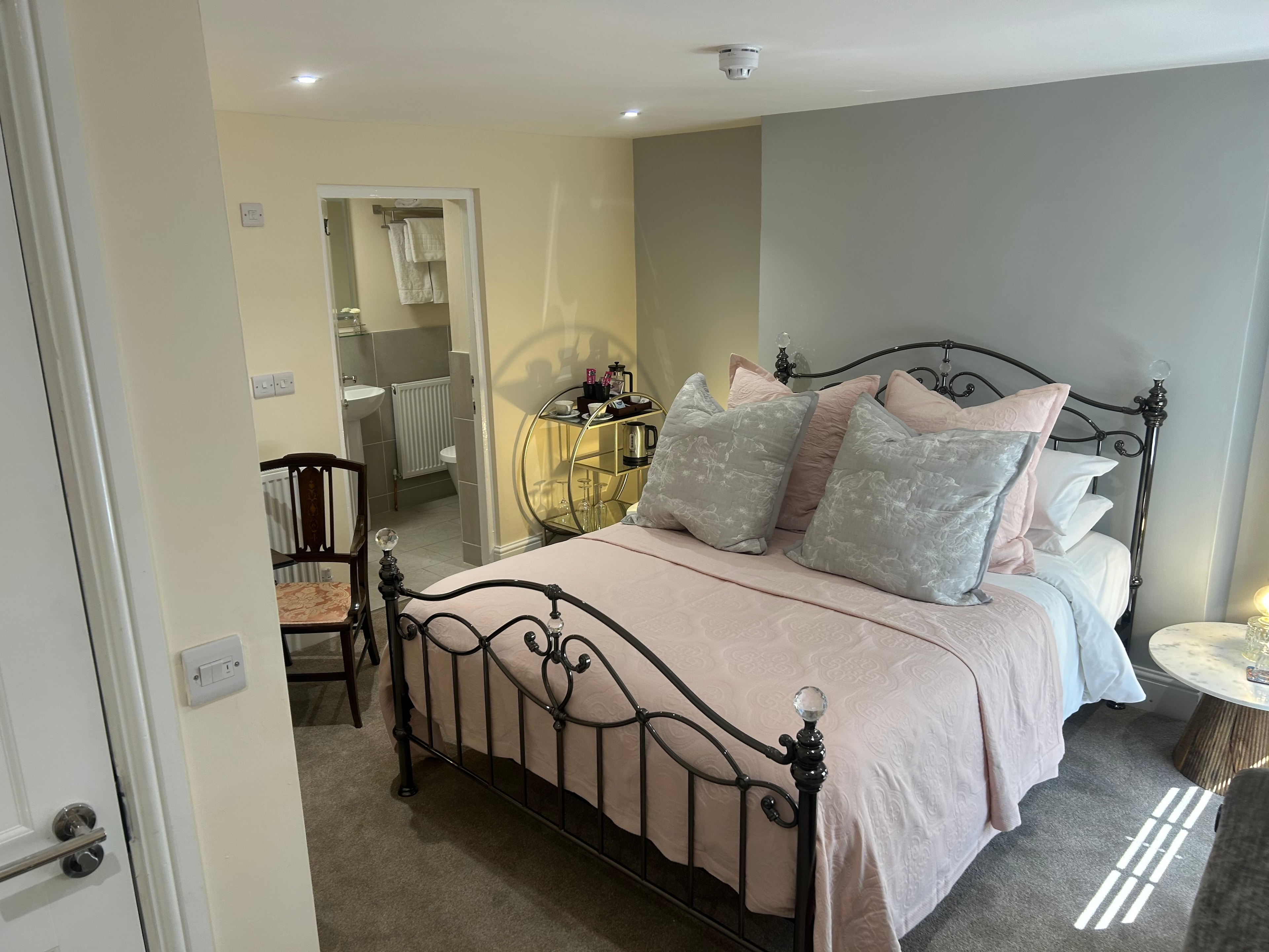 Gallery — bedroom with metal bed and en-suite doorway